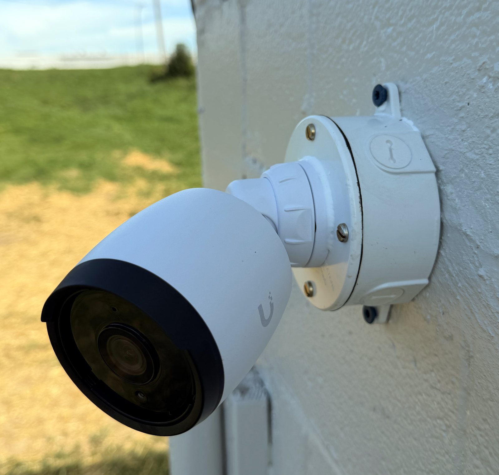Bullet camera on a white weatherproof junction box on a block wall